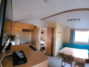 Habitación con escritorio y habitación con cama en Camping Le Brochet, en Péronne