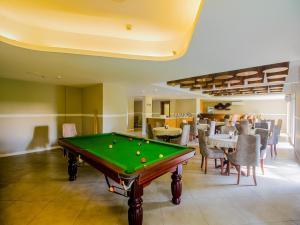 De Amour - A Dreamy Getaway in Anjuna في أنجونا: طاولة بلياردو في غرفة بها طاولات وكراسي