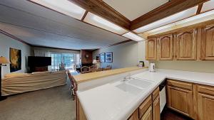a kitchen with a sink and a living room at Lakeview 826 Condo #108 Condo in Mammoth Lakes