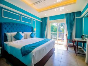 a blue bedroom with a bed and a window at De Amour - A Dreamy Getaway in Anjuna in Anjuna +43 photos