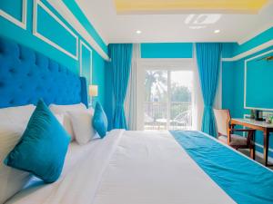 De Amour - A Dreamy Getaway in Anjuna في أنجونا: غرفة نوم زرقاء مع سرير كبير ونافذة +39 صورة