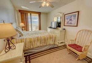 a bedroom with a bed and a television and a chair at Phoenix II 2045 in Orange Beach