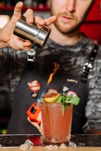 Een man giet een drankje in een cocktail. bij BoogelWoogel Bar&Hotel Rosa Khutor in Esto-Sadok