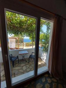 a room with a sliding glass door with a view of the ocean at Beautiful house located on a hill with a spectacular sea view in Samos Island in Koumeika