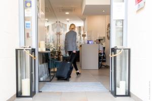 une femme debout dans un magasin cherchant une fenêtre dans l'établissement Hôtel Versailles Chantiers, à Versailles