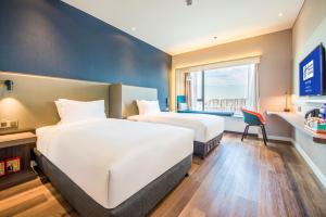 Cette chambre comprend 2 lits et une fenêtre. dans l'établissement Holiday Inn Express Foshan Beijiao, an IHG Hotel, à Shunde
