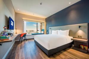 Un dormitorio con una gran cama blanca y una ventana en Holiday Inn Express Foshan Beijiao, an IHG Hotel, en Shunde