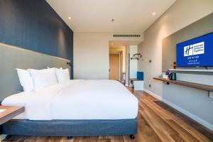 Cette chambre comprend un lit et une télévision. dans l'établissement Holiday Inn Express Foshan Beijiao, an IHG Hotel, à Shunde