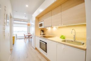 a kitchen with wooden cabinets and a sink at Apartment Aurinkoranta D5 saunallinen kaksio merinäkymällä Kalajoki in Kalajoki