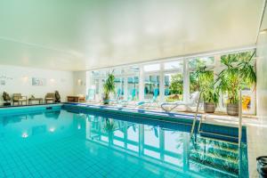 ein großer Pool mit großem Fenster in der Unterkunft Hotel Hasselhof Garni Vier Sterne in Braunlage