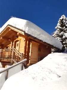 Cabaña de madera con nieve en el techo en Le Refuge des Marmottes, en Arêches