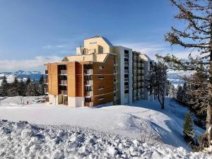 a building in the snow with snow covered ground at Studio Chamrousse, 1 pièce, 4 personnes - FR-1-340-95 in Chamrousse