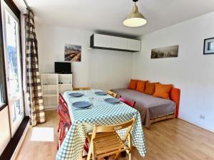 uma sala de estar com uma mesa e uma cama em Studio Chamrousse, 1 pièce, 3 personnes - FR-1-340-31 em Chamrousse
