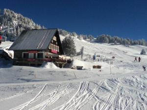 un lodge de esquí en una pista cubierta de nieve con pistas en la nieve en Studio Chamrousse, 1 pièce, 3 personnes - FR-1-340-31, en Chamrousse