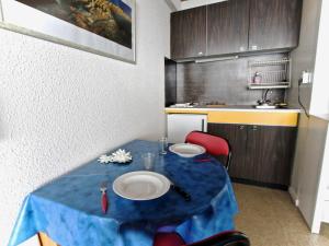 a small kitchen with a blue table in a room at Studio Chamrousse, 1 pièce, 3 personnes - FR-1-340-92 in Chamrousse