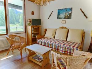 a living room with a couch and a table at Studio Chamrousse, 1 pièce, 4 personnes - FR-1-340-99 in Chamrousse