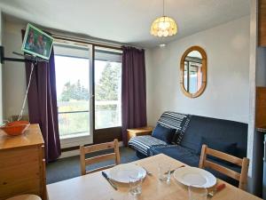 a living room with a blue couch and a table at Studio Chamrousse, 1 pièce, 6 personnes - FR-1-340-86 in Chamrousse