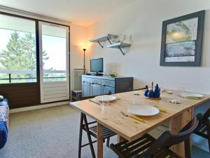 a dining room with a wooden table and chairs at Studio Chamrousse, 1 pièce, 4 personnes - FR-1-340-121 in Chamrousse