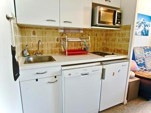 a small kitchen with a sink and a microwave at Studio Chamrousse, 1 pièce, 4 personnes - FR-1-340-121 in Chamrousse