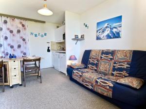 a living room with a couch and a table at Studio Chamrousse, 1 pièce, 4 personnes - FR-1-340-121 in Chamrousse