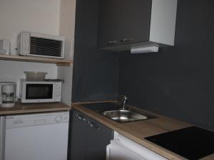 a small kitchen with a sink and a microwave at Studio Chamrousse, 1 pièce, 4 personnes - FR-1-340-108 in Chamrousse