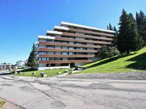 un gran edificio en una colina junto a una calle en Studio Chamrousse, 1 pièce, 3 personnes - FR-1-340-109 en Chamrousse