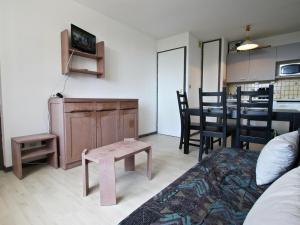 a living room with a couch and a table with chairs at Appartement Chamrousse, 2 pièces, 6 personnes - FR-1-340-120 in Chamrousse