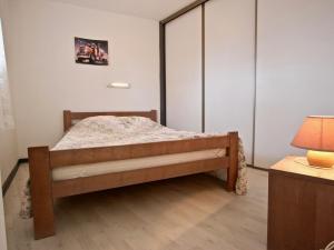 a small bedroom with a bed and a lamp at Appartement Chamrousse, 2 pièces, 6 personnes - FR-1-340-120 in Chamrousse