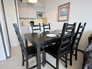 una mesa de comedor negra y sillas en la cocina en Appartement Chamrousse, 2 pièces, 6 personnes - FR-1-340-120 en Chamrousse