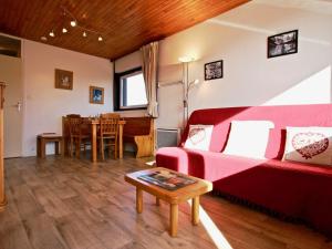 シャンルッスにあるAppartement Chamrousse, 2 pièces, 4 personnes - FR-1-340-81のリビングルーム(赤いソファ、テーブル付)