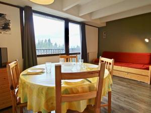 une salle à manger avec une table et une grande fenêtre dans l'établissement Studio Chamrousse, 1 pièce, 4 personnes - FR-1-340-153, à Chamrousse