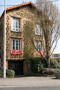 a brick building with a window and a tree at Villa Liberté Verdun in Villejuif