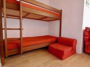um quarto com 2 beliches e uma cadeira vermelha em Studio Chamrousse, 1 pièce, 4 personnes - FR-1-340-91 em Chamrousse