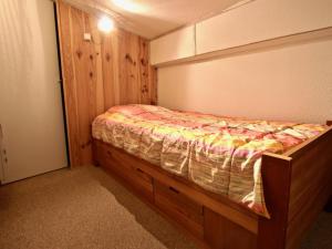 a small bedroom with a bed with a wooden frame at Appartement Chamrousse, 2 pièces, 7 personnes - FR-1-340-229 in Chamrousse