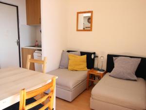 uma pequena sala de estar com um sofá e uma mesa em Studio Chamrousse, 1 pièce, 4 personnes - FR-1-340-199 em Chamrousse
