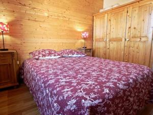 a bedroom with a bed with a wooden wall at Appartement Chamrousse, 3 pièces, 6 personnes - FR-1-340-204 in Chamrousse