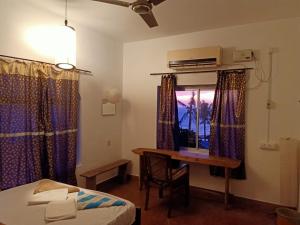 a bedroom with a desk and a bed and a table at The Lost Hostel, Varkala - Helipad in Varkala