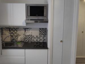 a kitchen with a microwave and a counter with a sink at Studio Chamrousse, 1 pièce, 4 personnes - FR-1-340-214 in Chamrousse