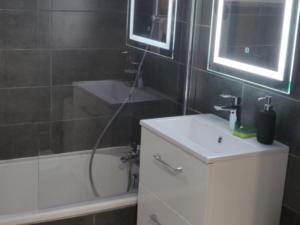 a bathroom with a white sink and a bath tub at Studio Chamrousse, 1 pièce, 4 personnes - FR-1-340-214 in Chamrousse