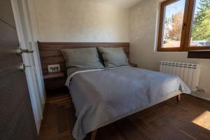 a bedroom with a bed with a wooden headboard and a window at Vista47 Zoned II Kopaonik in Kopaonik +39 photos
