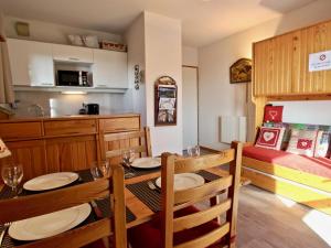 uma cozinha e sala de jantar com mesa e cadeiras em Appartement Chamrousse, 2 pièces, 4 personnes - FR-1-340-210 em Chamrousse