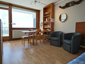 a living room with a dining room table and chairs at Studio Chamrousse, 1 pièce, 4 personnes - FR-1-549-48 in Chamrousse