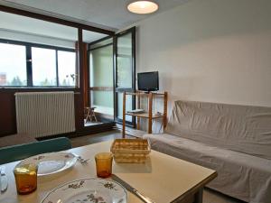 a living room with a couch and a table at Studio Chamrousse, 1 pièce, 3 personnes - FR-1-549-35 in Chamrousse