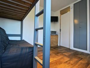 a small bedroom with a bunk bed and a kitchen at Studio Chamrousse, 1 pièce, 3 personnes - FR-1-549-12 in Chamrousse