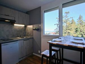 a kitchen with a table with chairs and a window at Studio Chamrousse, 1 pièce, 3 personnes - FR-1-549-12 in Chamrousse