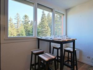 a room with a table and stools in front of a window at Studio Chamrousse, 1 pièce, 3 personnes - FR-1-549-12 in Chamrousse