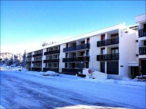 a snow covered street in front of an apartment building at Studio Chamrousse, 1 pièce, 3 personnes - FR-1-549-35 in Chamrousse