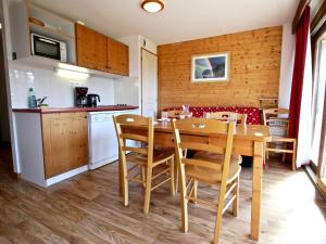 uma cozinha e sala de jantar com uma mesa de madeira e cadeiras em Appartement Chamrousse, 3 pièces, 6 personnes - FR-1-549-1 em Chamrousse