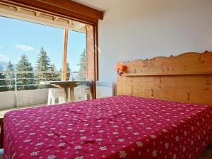 a bedroom with a bed and a large window at Appartement Chamrousse, 3 pièces, 6 personnes - FR-1-549-1 in Chamrousse