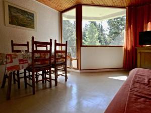 a dining room with a table and chairs and a window at Studio Chamrousse, 1 pièce, 4 personnes - FR-1-549-61 in Chamrousse